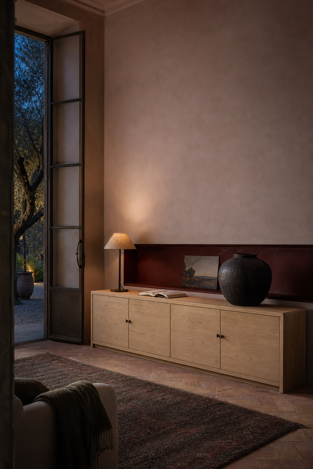 Conceptual AI-modified oxblood and chalk-pink salon with a long pale-oak sideboard, one low painting, a dark ceramic vessel, and an open garden doorway